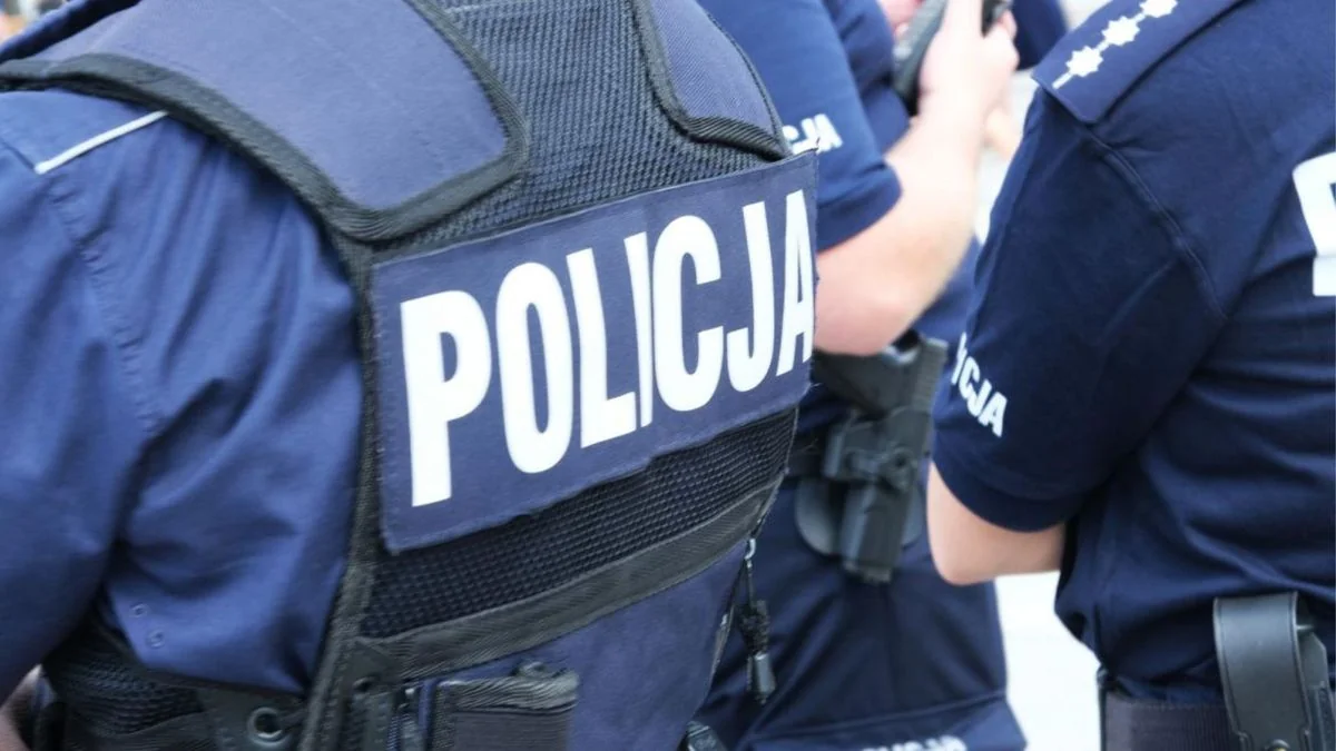 Польські поліцейські в синій формі з написом POLICJA на спині