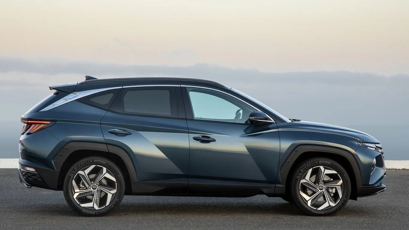 Синій Hyundai Tucson кросовер у боковому ракурсі на тлі моря