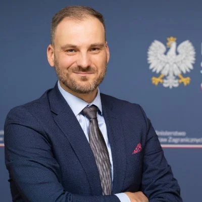 Речник МЗС Польщі Мачей Вевюр у костюмі на фоні герба