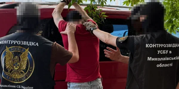 Співробітники СБУ затримують чоловіка в червоній футболці біля фургона
