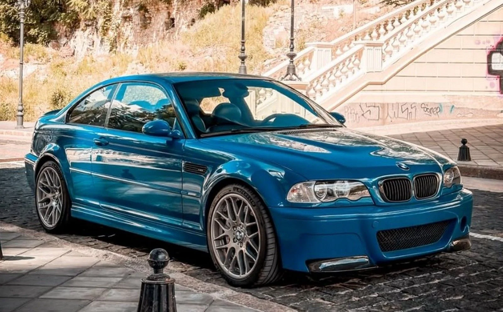 Синий BMW M3 E46 Coupe Laguna Seca Blue на брусчатке возле лестницы