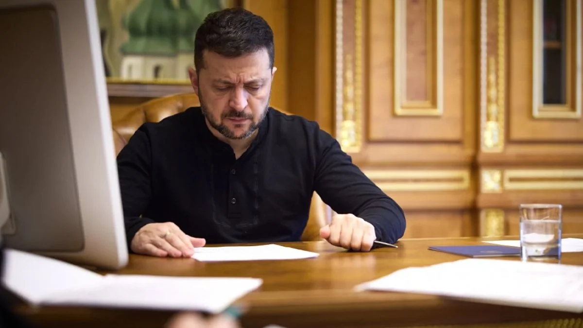 Володимир Зеленський за столом уважно переглядає документи в кабінеті