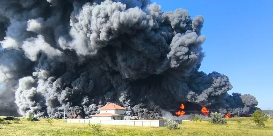 Величезна чорна хмара диму над будинком з червоним дахом і полумям