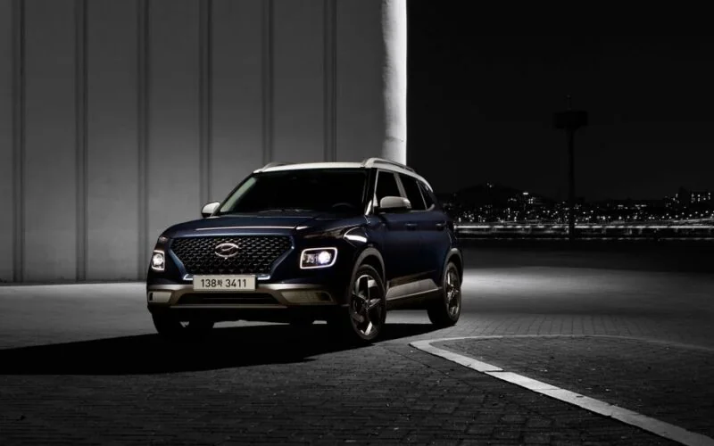 Темно-синій Hyundai кросовер з увімкненими фарами на нічній дорозі