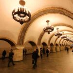 Інтерєр станції метро з арками, люстрами та пасажирами