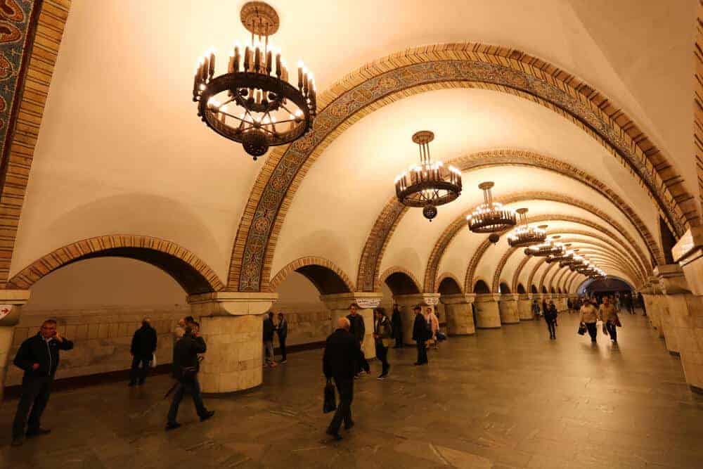 Інтерєр станції метро з арками, люстрами та пасажирами